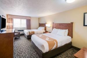 Una habitación de hotel con dos camas y un televisor de pantalla plana. en Quality Inn & Suites Coeur d'Alene, en Coeur d'Alene
