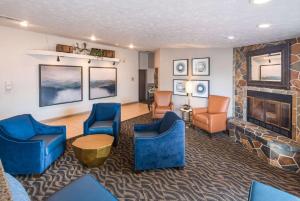a living room with blue chairs and a fireplace at Quality Inn & Suites Coeur d'Alene in Coeur d'Alene