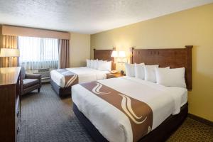 a hotel room with two beds and a chair at Quality Inn & Suites Coeur d'Alene in Coeur d'Alene