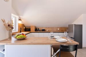 a kitchen with a table with a bowl of fruit on it at Apartman AdriAttic in Milna