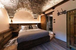 a bedroom with a bed and a brick ceiling at Chez'Alma in Joussaud