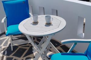 a table and two chairs with cups on it at Naxian Purity in Glinado Naxos