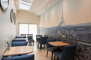 a restaurant with tables and chairs and a view of the eiffel tower at Helussi H&ocirc;tel in Paris