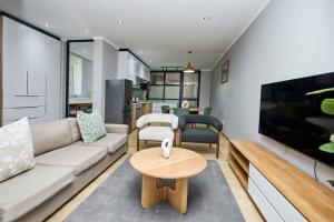 a living room with a couch and a table at Brooklyn Modern Apartment in Pretoria