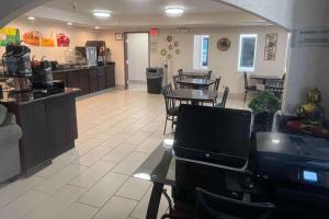 a restaurant with a table and chairs and a kitchen at Quality Inn Raton, NM in Raton