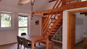 a dining room with a wooden table and stairs at Doppelhaushälfte Ostwind vom Naturhof Usedom in Bannemin +24 photos