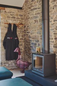 a living room with a brick wall and a fireplace at The Cowshed in Glastonbury +29 photos