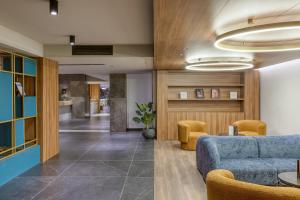 a living room with a blue couch and chairs at Solana Hotel & Spa in Mellieħa