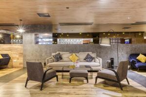 a living room with a couch and a table and chairs at Solana Hotel & Spa in Mellieħa
