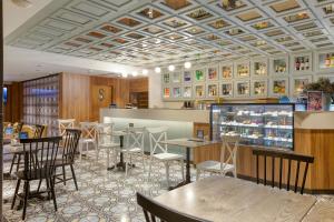 a restaurant with tables and chairs and a counter at Solana Hotel & Spa in Mellieħa