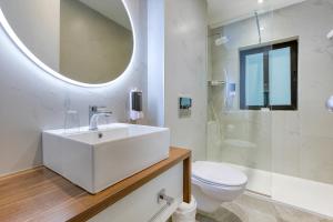 a bathroom with a sink and a toilet and a mirror at Solana Hotel & Spa in Mellieħa