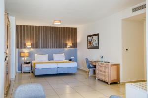 a bedroom with a bed and a desk and a bed sidx sidx sidx at Solana Hotel & Spa in Mellieħa