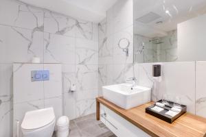 a white bathroom with a sink and a toilet at Solana Hotel & Spa in Mellieħa