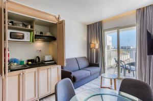 a living room with a couch and a table at Solana Hotel & Spa in Mellieħa