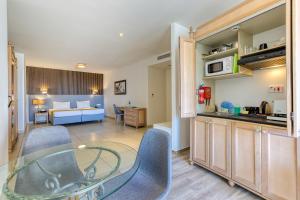 a kitchen and a living room with a table and chairs at Solana Hotel & Spa in Mellieħa