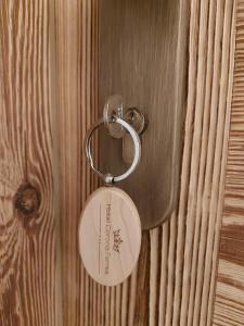 a key chain is attached to a wooden door at Hotel Corona Ferrea in Sappada