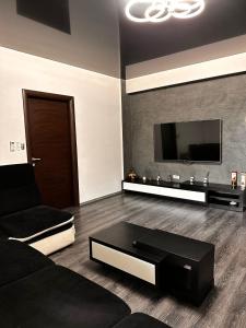 a living room with a black couch and a flat screen tv at Apartament cu 2 dormitoare in Constanţa