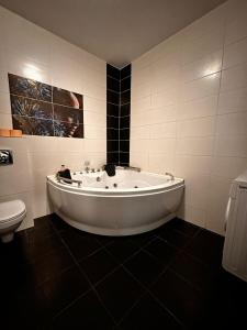 a white bath tub in a bathroom with a toilet at Apartament cu 2 dormitoare in Constanţa