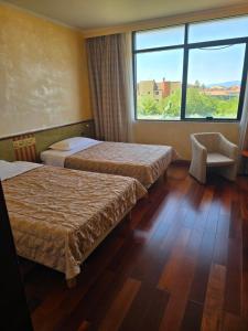 a hotel room with two beds and a window at Grand Hotel Europa in Isernia