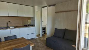 a kitchen with a couch and a table in a room at Mobile homes Jezera Lovišća Premium in Jezera