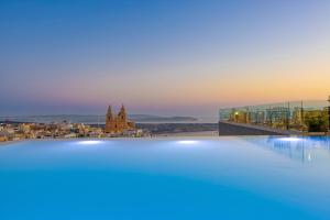 a swimming pool with a view of a city at Solana Hotel & Spa in Mellieħa