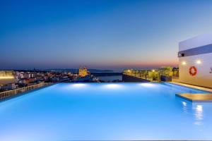 a pool on the roof of a building at night at Solana Hotel & Spa in Mellieħa