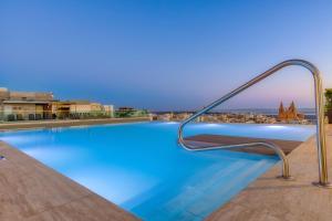 a swimming pool with a view of the city at Solana Hotel & Spa in Mellieħa