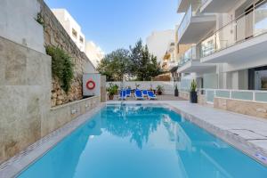 a swimming pool with blue water in a building at Solana Hotel & Spa in Mellieħa