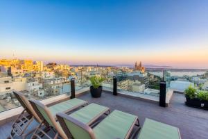 a balcony with chairs and a view of a city at Solana Hotel & Spa in Mellieħa