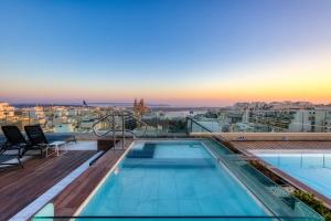 a pool on the roof of a building with a view at Solana Hotel & Spa in Mellieħa