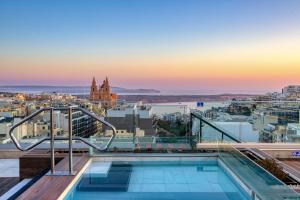 a pool on the roof of a building with a view at Solana Hotel & Spa in Mellieħa