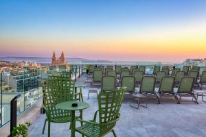 a row of chairs and tables on a roof at Solana Hotel & Spa in Mellieħa