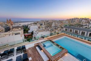 a pool on the roof of a building with a view at Solana Hotel & Spa in Mellieħa