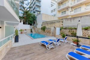 a patio with lounge chairs and a swimming pool at Solana Hotel & Spa in Mellieħa