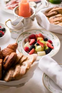 a table topped with plates of fruit and pastries at Four Seasons Hotel Firenze in Florence