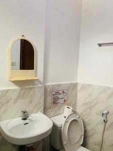 a bathroom with a sink and a toilet and a mirror at Francis Dale Lodge L8 in El Nido +7 photos
