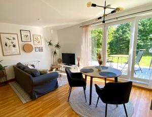 a living room with a couch and a table and chairs at Stilvolles Appartement in Jena