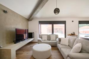 a living room with a couch and a tv at Casa do Moleiro in Mortágua