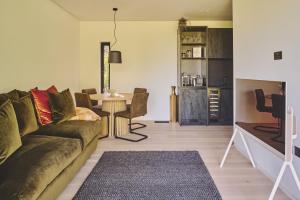 a living room with a couch and a table at Whispering Leaves in Glastonbury