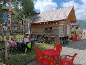 a group of people sitting at a table in front of a building at Guest House Cafe Nita in Ushguli