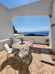 a patio with a table and chairs on a balcony at La Roccetta in Capri