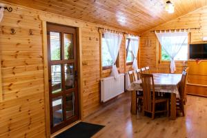 a dining room with a table in a log cabin at Vivien vendégház in Borzont +30 photos