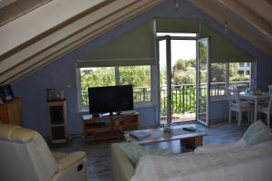 Una sala de estar con un sofá y un televisor. en Villa Gerani, en Gerani
