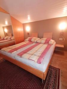 Una cama grande en una habitación con dos lámparas. en Ferienwohnung am Rhein, en Koblach