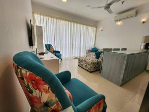 a living room with a blue couch and a kitchen at Beach Front Apartment - Wattala in Wattala