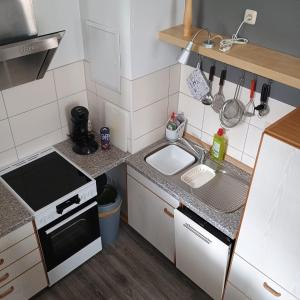 a small kitchen with a sink and a stove at Ferienwohnung Bender 2 in Gemünden +5 photos