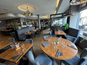 a restaurant with wooden tables and chairs at Hôtel Villa Des 2 Caps in Wimereux