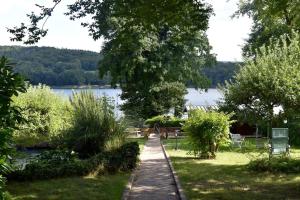 a walkway through a park next to a lake at Ô bord du Lac - Canoé, barbecue in Chaumard