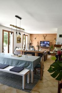 a living room with a table and a kitchen at Ô bord du Lac - Canoé, barbecue in Chaumard