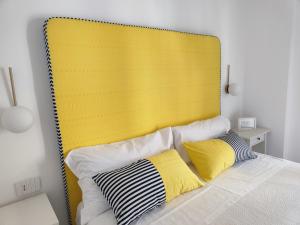 een bed met een geel hoofdeinde in een kamer bij Case Borgo Vacanze in Letojanni